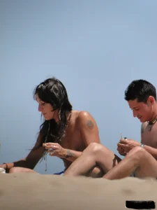 Topless lady on the beach in a gold thong with a nice ass