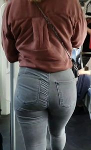 Blond girl in tight grey jeans waiting for the bus
