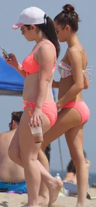 Two sexy girls in peach and pink bikinis on the beach