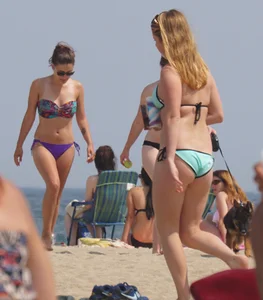 Cute girls in light blue and purple bikinis on the beach