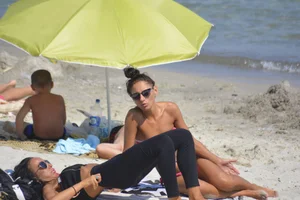 Sexy beach babe in pink bikini makes it a string bikini