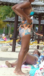 Sexy black babe in various bikinis on the beach while on vacation