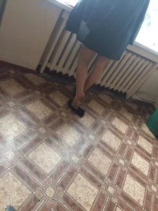 Teen in Pantyhose Standing by the Window with Her Shoe Half Taken Off Candid Photo