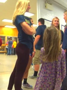 Skinny college teen in leggings bending over a drinking fountain