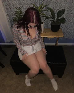 Non-candid busty girl in a skirt wearing glasses