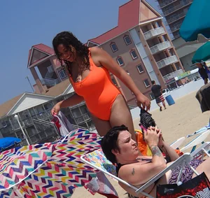 Beach girl with big boobs in an orange swimsuit