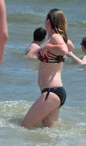 Cute beach girl in little bikini in the water