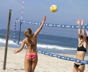 Hot girls playing beach volleyball in bikinis and shorts
