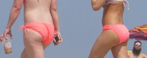 Two sexy girls in peach and pink bikinis on the beach
