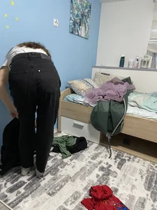 Young Girl In Black Jeans Bending Over in Her Bedroom