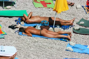 Nudist couple on the beach, girl has amazing tits and nice ass in a thong