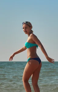 Sexy blonde milf on the beach in blue thong bikini and showing nice camel toe