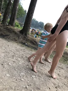 Cute Barefoot Girl in a Black Body Swimsuit Walking on a Road