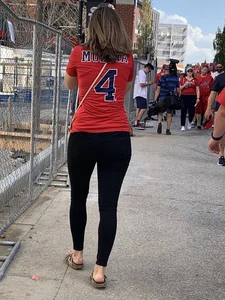 Bunch of girls in various outfits at a Cardinals baseball game