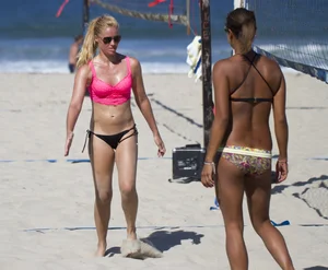 Hot girls playing beach volleyball in bikinis and shorts