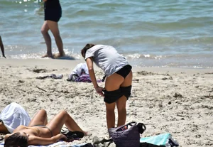 Sexy girl undressing to her bikini on the beach with an amazing body