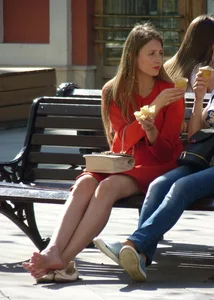 Girl Sitting on Street Bench with Bare Feet Candid