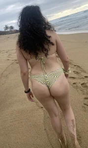 Milf in a swimsuit walking at the beach candid photo