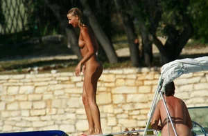 Two sexy nude beach friends getting some sun