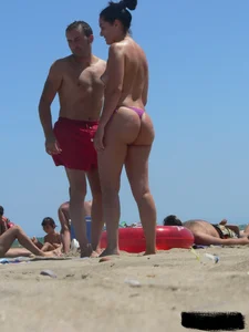Purple thong topless lady on the beach gets oiled up by her husband