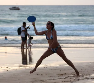 Older lady playing on the beach in her bikini