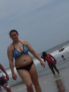 Big boobed girl on the beach in blue and black bikini