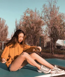 Cute Girl in Mini Shorts Sitting on the Ping-pong Table on the Suburb Playground