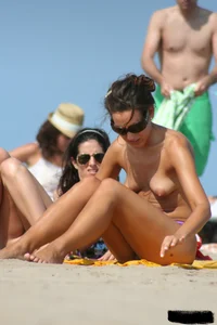 2 topless girls at the beach in thongs