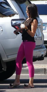 Milf brunette in purplish-pink leggings looking sexy in the parking lot