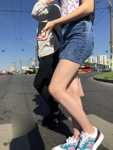 Cute Girl in a Short Denim Skirt Walking on a Street And Waiting on a Crosswalk Gallery