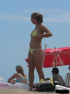 Sexy blonde on the beach in a yellow thong bikini