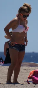 Thick blonde girl in an orange bikini on the beach