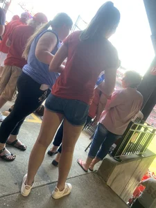 Bunch of girls in various outfits at a Cardinals baseball game