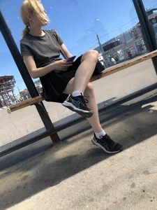 Very cute bespectacled blonde candid teen sitting with crossed legs at the bus stop creepshots