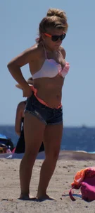 Thick blonde girl in an orange bikini on the beach