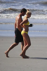Skinny cute blonde on the beach in yellow bikini