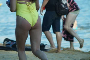 Sexy Girl in One-Piece Yellow Swimsuit Walking on the Beach Candid Photo Gallery