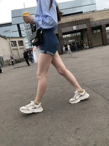 Candid Girl in Blue Denim Shorts and Sneakers Walking Down the Street - Hot Legs Crepshots Collection