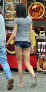 Skinny brunette in tiny denim shorts showing a little cheek