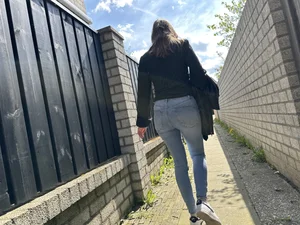 Sexy girl in tight blue jeans walking down a suburban street creepshots