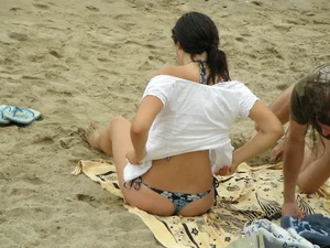 Sexy girl in a blue floral thong bikini at the beach