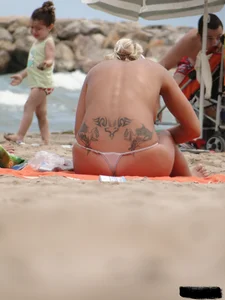 Tattooed blonde with big tits topless and in thong