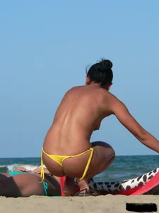 Bunch of sexy babes on the beach topless and in thong bikinis