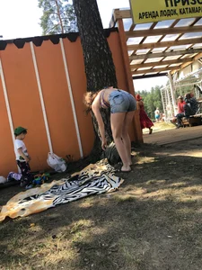 Young Skinny Girl Taking Off Her Denim Shorts Leaving a Swimsuit - Bending Over While Laying a Blanket on the Ground at a Lake Nature Park Gallery