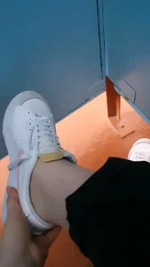 Video of a teen girl showing her feet in pantyhose while sitting in a toilet cubicle