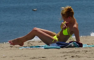 Sexy ass blonde milf on the beach in a thong with cameltoe and bending over