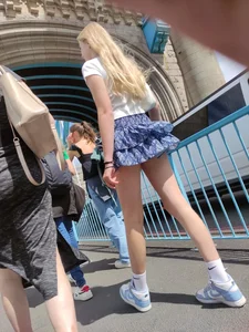 Skinny blonde girl wearing a short skirt with long slim legs street creepshots