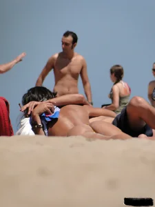 Topless lady on the beach in a gold thong with a nice ass