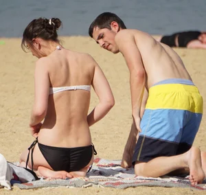 Sexy girl on the beach laying out and bending over in her bikini