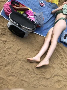 Cute Candid Girl in a Green Swimsuit With Pale Skin Lying on the Beach